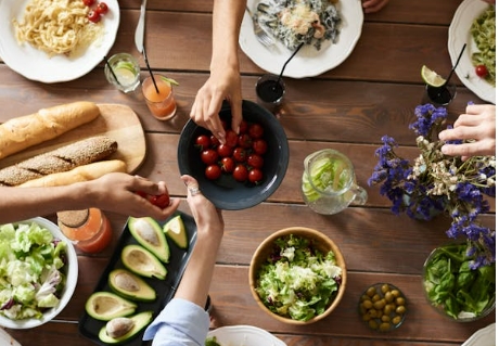 people share fruit and dishes above a table